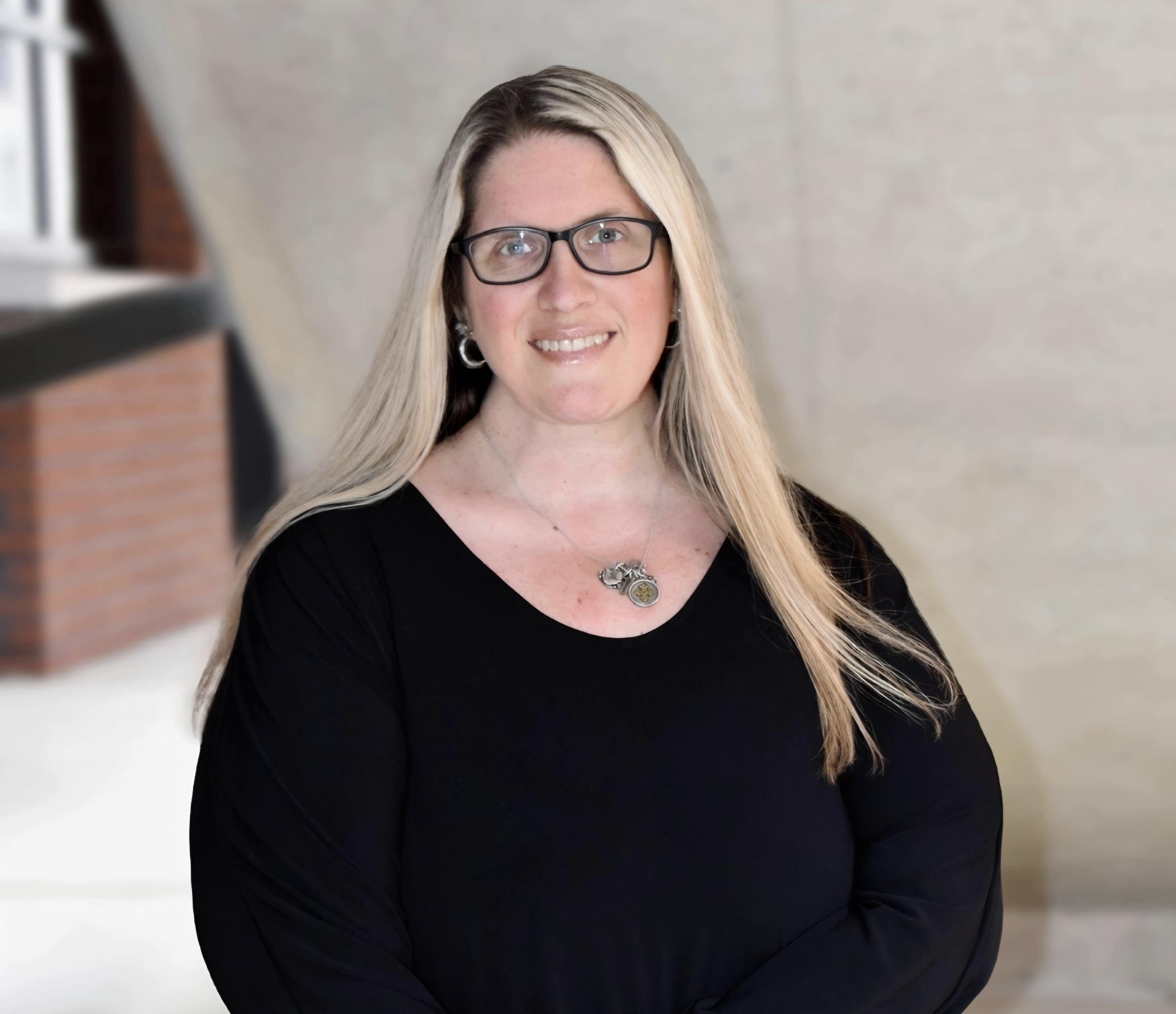 Southern Neurosurgery team member standing outside wearing black shirt and black framed glasses