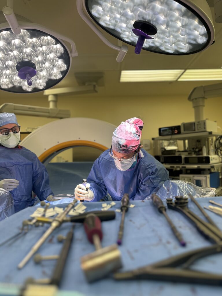 Dr. Grunch performing procedure in operating room with used surgical tools in foreground