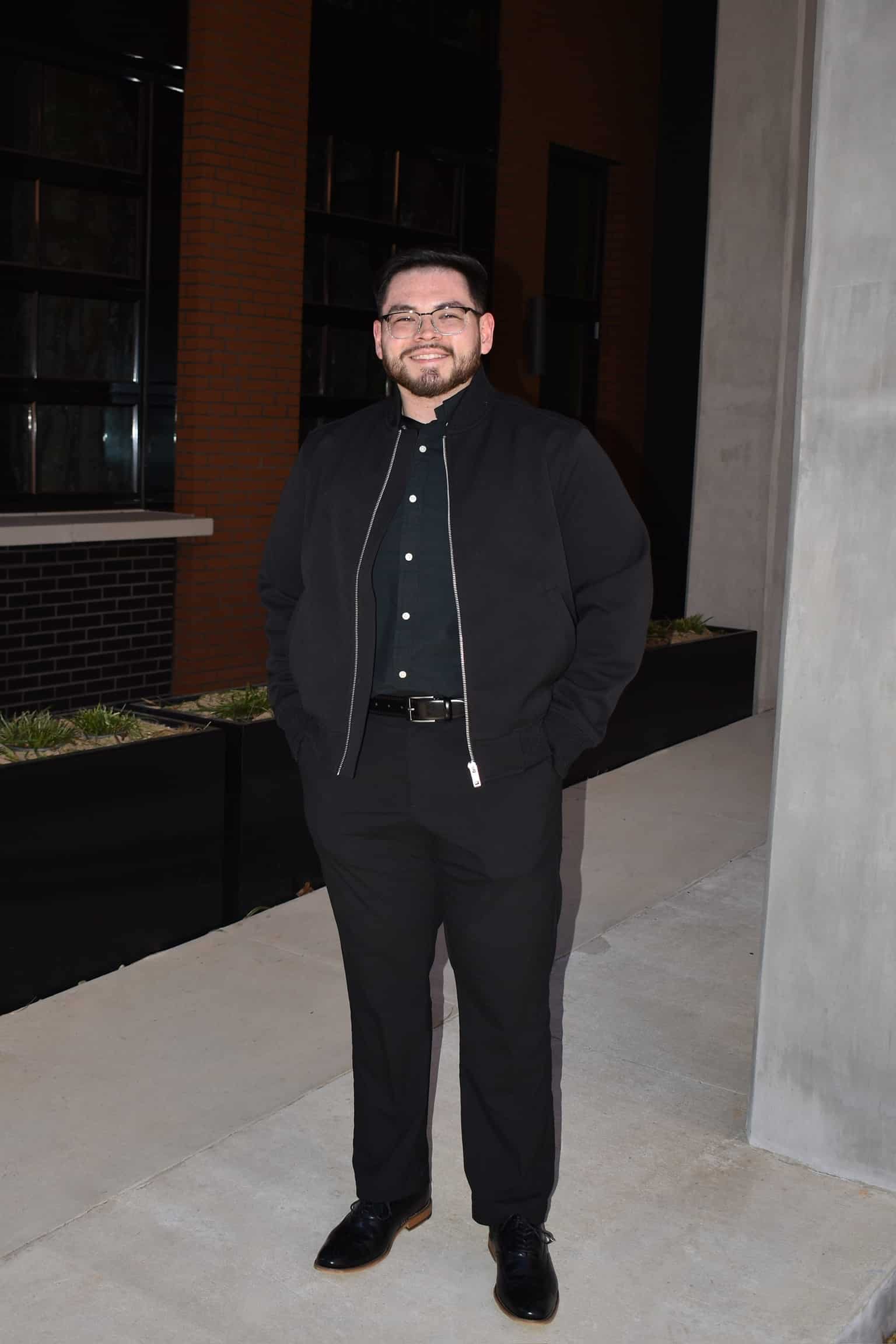 Alex Fernandez wearing black dress outfit with black jacket