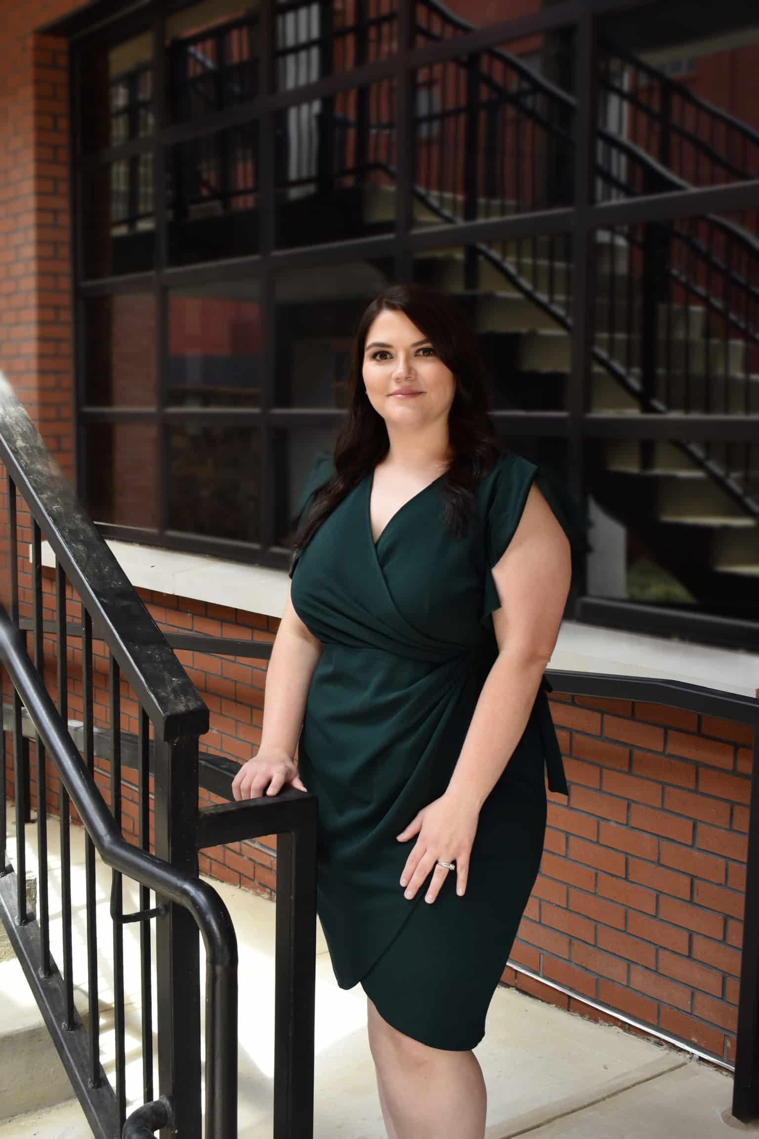 Southern Neurosurgery team member standing outside building wearing green dress