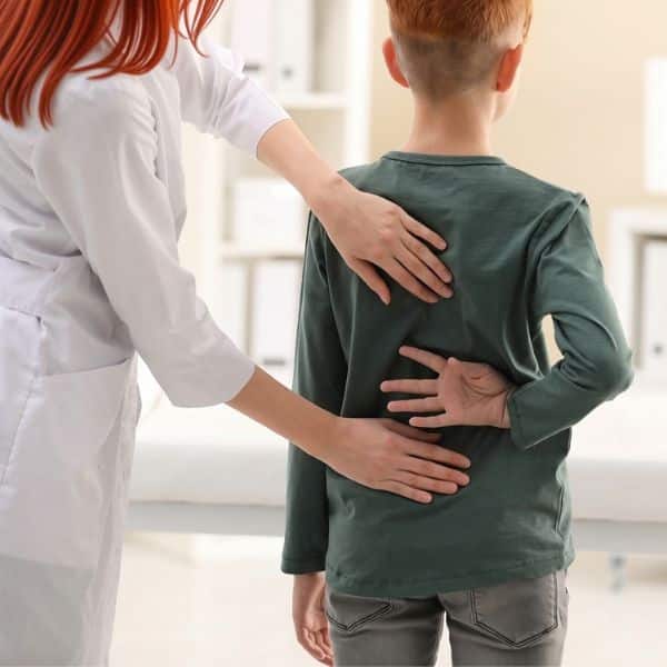 Doctor examining a child’s back during a medical appointment